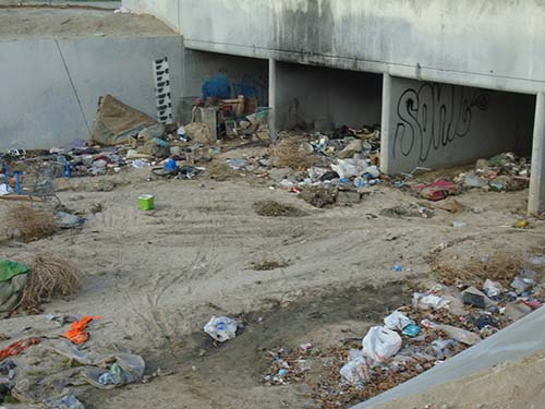 wash and tunnel full of trash from a homeless encampment