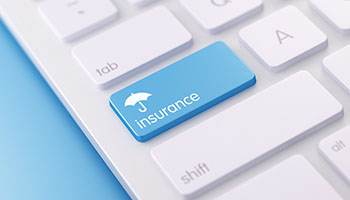 computer keyboard with an umbrella above the word insurance on a blue key