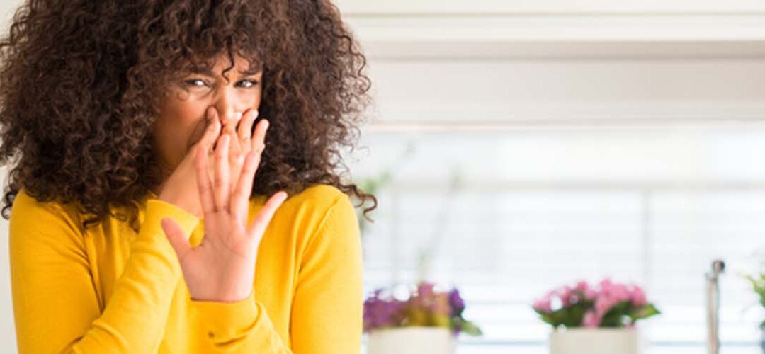 woman pinching her nose because of a dead body odor