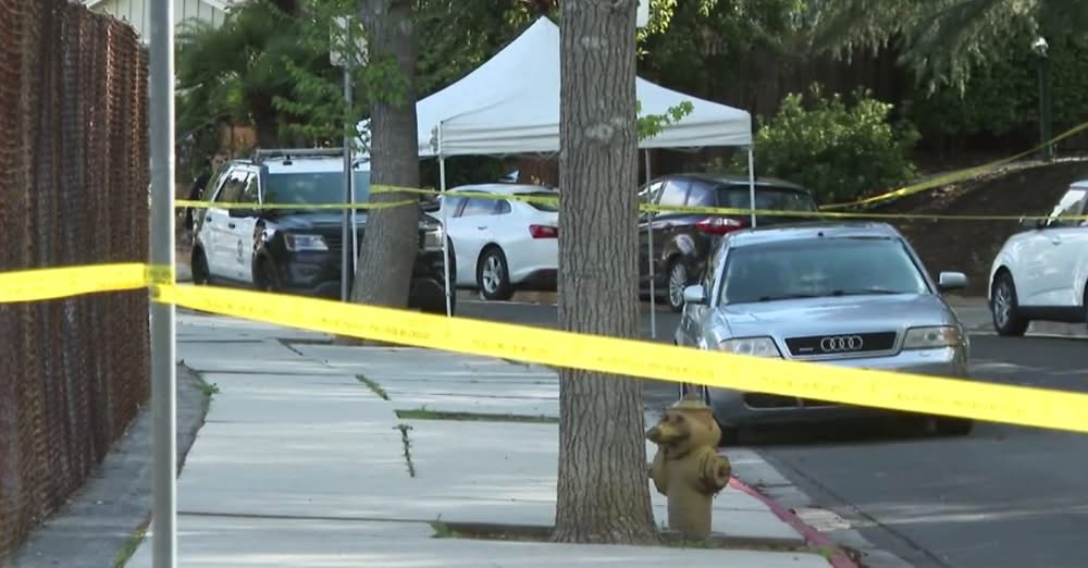 street in Woodland Hills, CA that is roped off with yellow crime scene tape